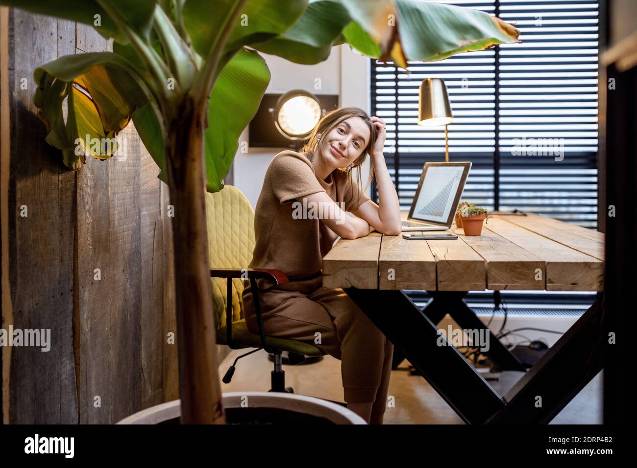 Ritratto di una giovane donna in tuta domestica al splendido e accogliente ufficio a casa Foto Stock
