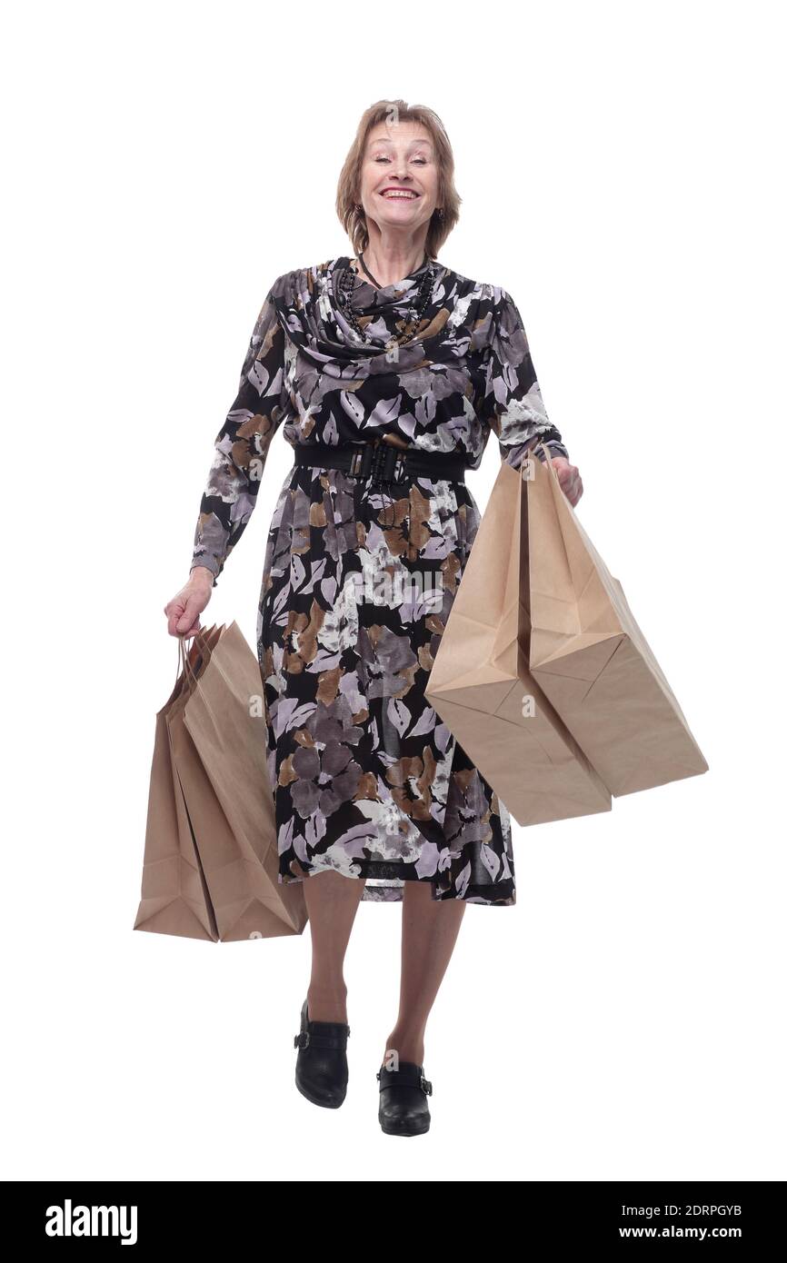 Donna caucasica anziana che cammina con borse per lo shopping sorridente al telespettatore Foto Stock