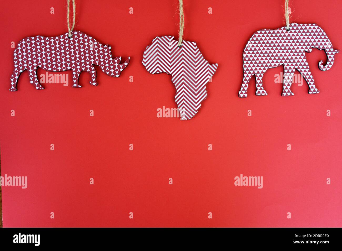 Rinoceronti, Africa, ed elefanti ornamenti natalizi su sfondo rosso. Foto Stock