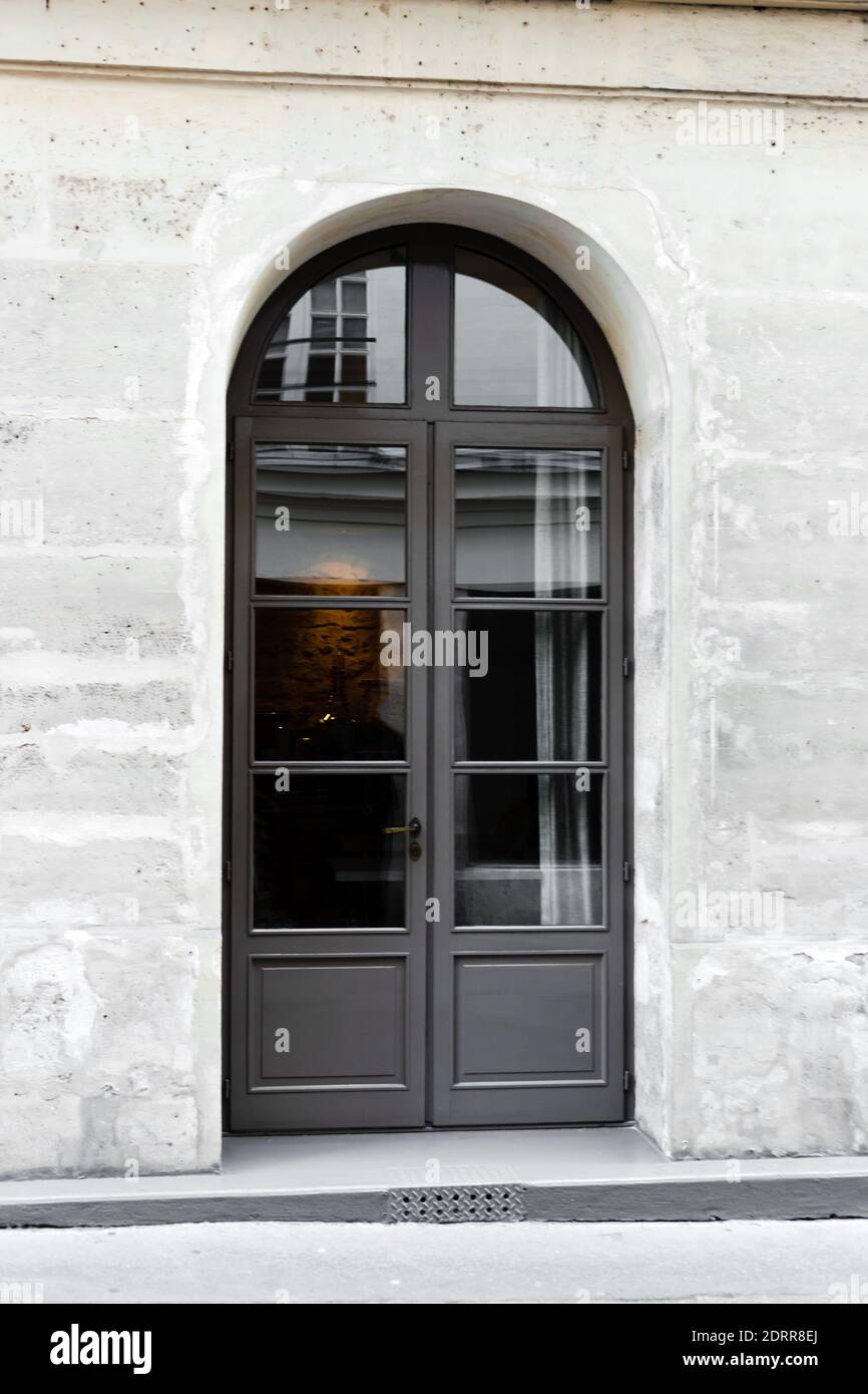 Nuova porta a doppia anta in legno grigio ad arco. Cancello di legno - ingresso. Vintage vecchia porta grigia in pietra muro in cemento casa Parigi Francia Foto Stock