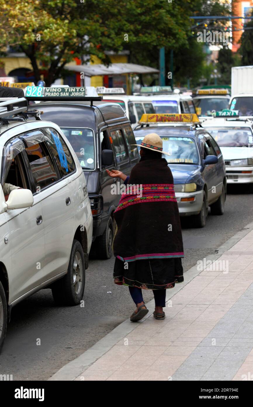 Donna di Quechua dal Dipartimento di Potosi del nord che indossa abiti tradizionali che implichano dai conducenti nella principale via centrale di El Prado, la Paz, Bolivia. Un gran numero di donne e bambini vengono a la Paz dal nord della zona di Potosi (una delle più povere della Bolivia) intorno al periodo natalizio, in particolare per implorare, ricevere regali e solidarietà generale dalla popolazione. Foto Stock