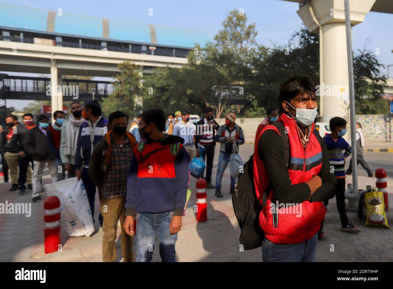 I passeggeri che indossano maschere come misura preventiva contro il coronavirus aspettano in fila un test Covid19 presso una stazione degli autobus di Delhi. I casi di coronavirus in India hanno attraversato 10 milioni di persone con nuove infezioni che si sono tuffate ai livelli più bassi in tre mesi, mentre il paese si prepara per una massiccia vaccinazione COVID-19 nel nuovo anno. Foto Stock