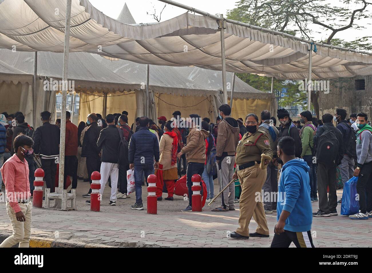 I passeggeri che indossano maschere come misura preventiva contro il coronavirus aspettano in fila un test Covid19 presso una stazione degli autobus di Delhi. I casi di coronavirus in India hanno attraversato 10 milioni di persone con nuove infezioni che si sono tuffate ai livelli più bassi in tre mesi, mentre il paese si prepara per una massiccia vaccinazione COVID-19 nel nuovo anno. Foto Stock