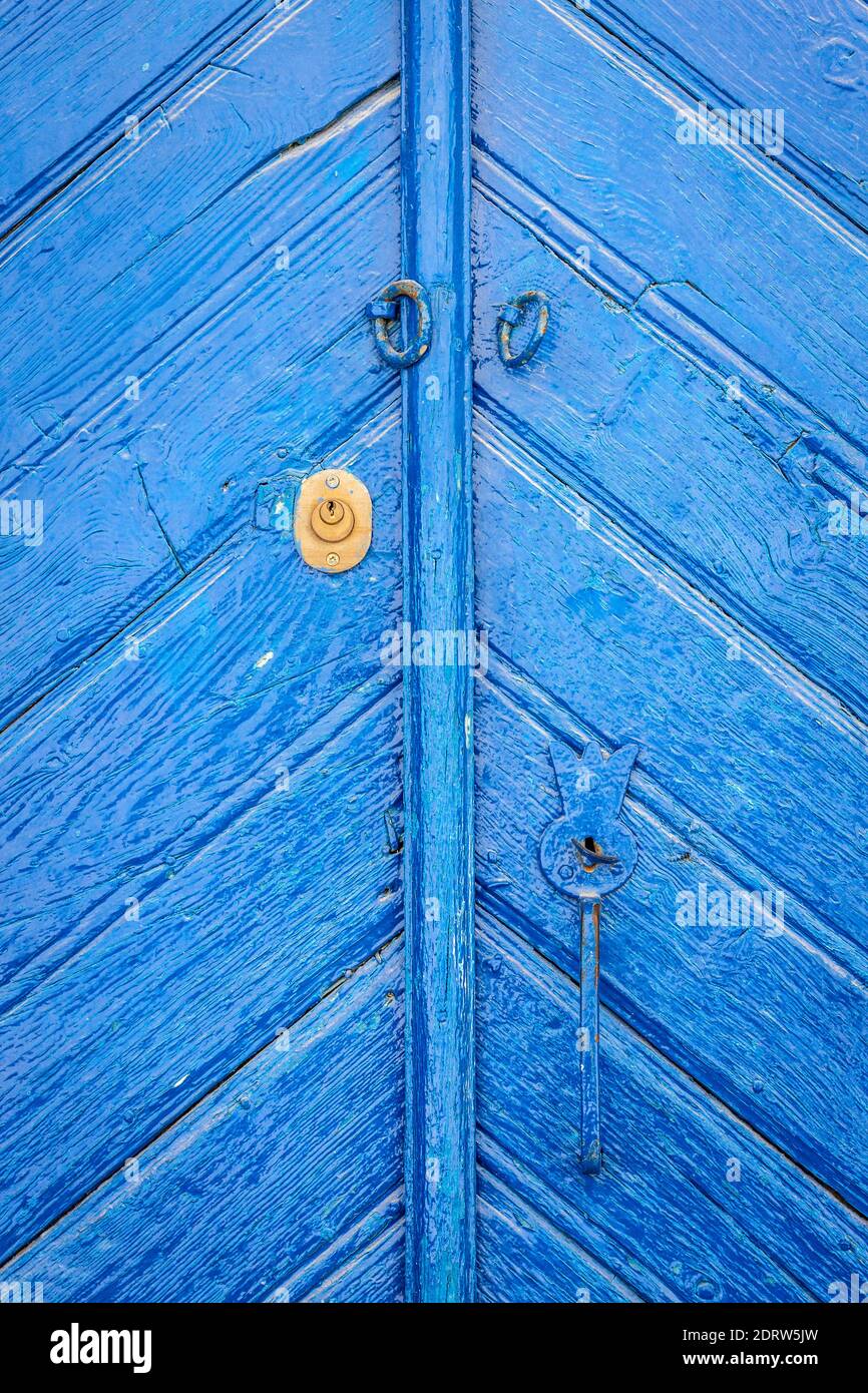 Chiusa vecchia porta di legno blu, chiaramente invecchiata e lavata a tempo. Foto Stock