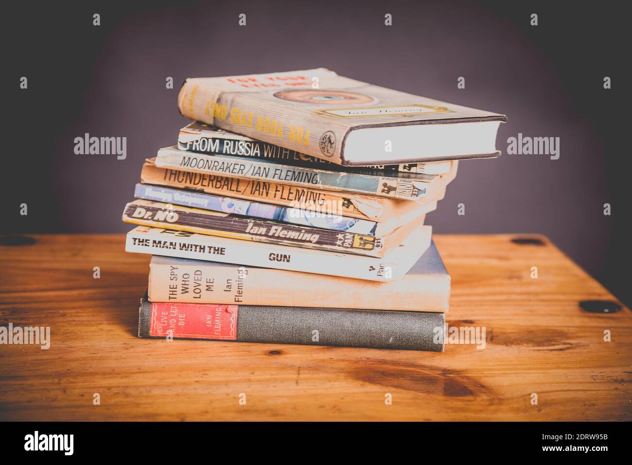 Una pila di James Bond 007 libri vintage su legno tabella Foto Stock