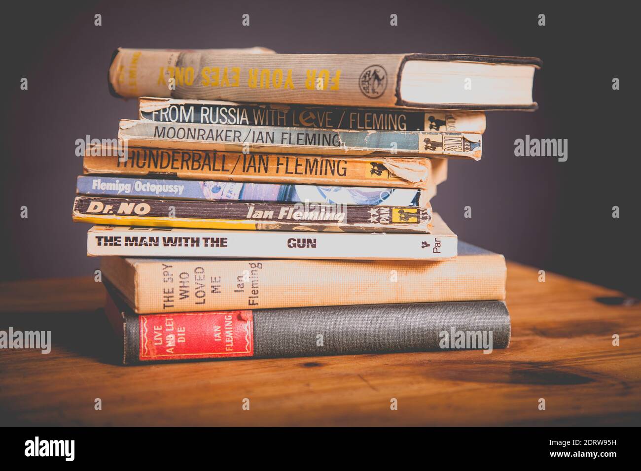 Una pila di James Bond 007 libri vintage su legno tabella Foto Stock