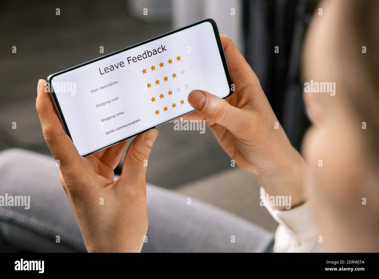 recensione del cliente - donna che usa il telefono per valutare la sua esperienza informazioni sul servizio di acquisto online e sulla qualità dei prodotti Foto Stock