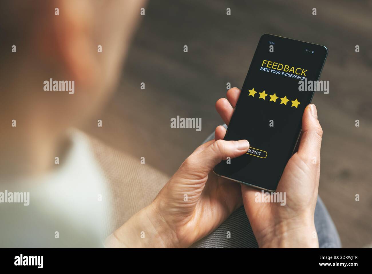 feedback del cliente - donna che usa il telefono per dare 5 stelle valutazione per un buon servizio Foto Stock