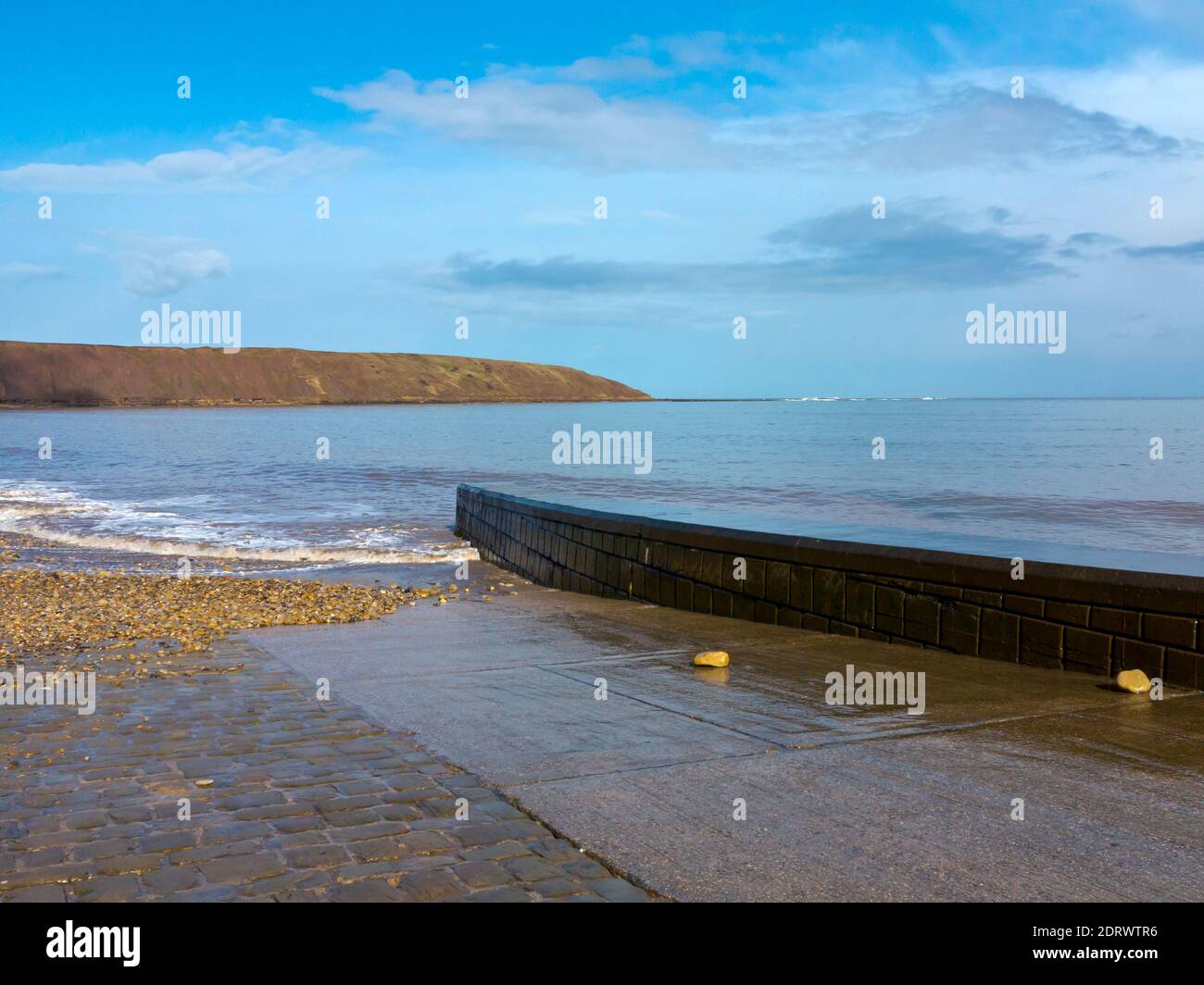 Onde e la passeggiata in alta marea sulla spiaggia A Filey una popolare località balneare nel North Yorkshire Costa nel nord dell'Inghilterra UK Foto Stock