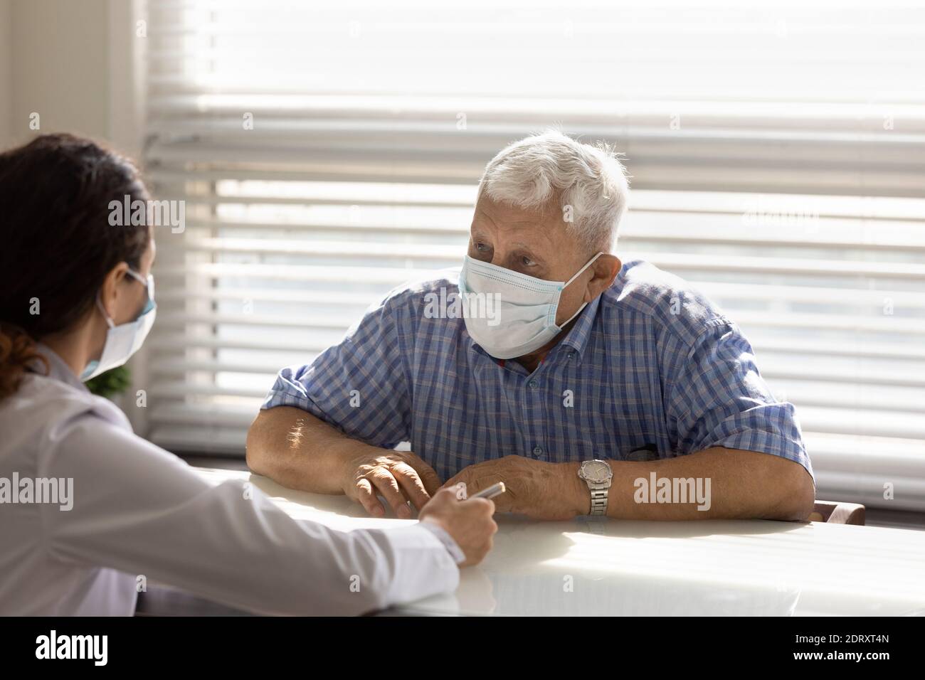 Paziente maschile maturo in maschera hanno consultazione con il medico Foto Stock