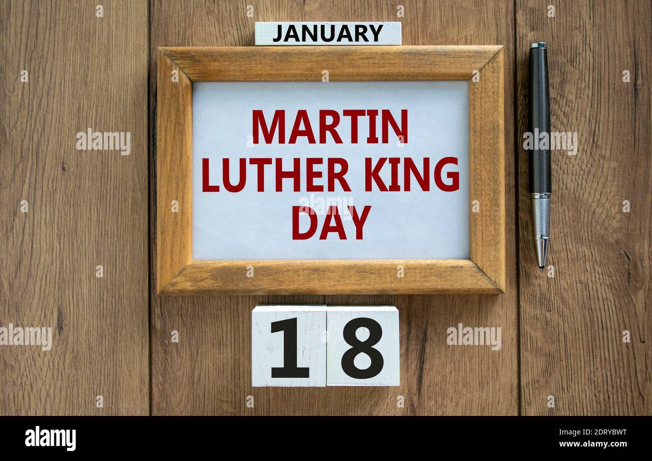 Simbolo MLK Day. Cornice con le parole 'Marin Luther King Day' su bel tavolo in legno, penna metallica e calandra in legno con data gennaio 18. MLK Foto Stock