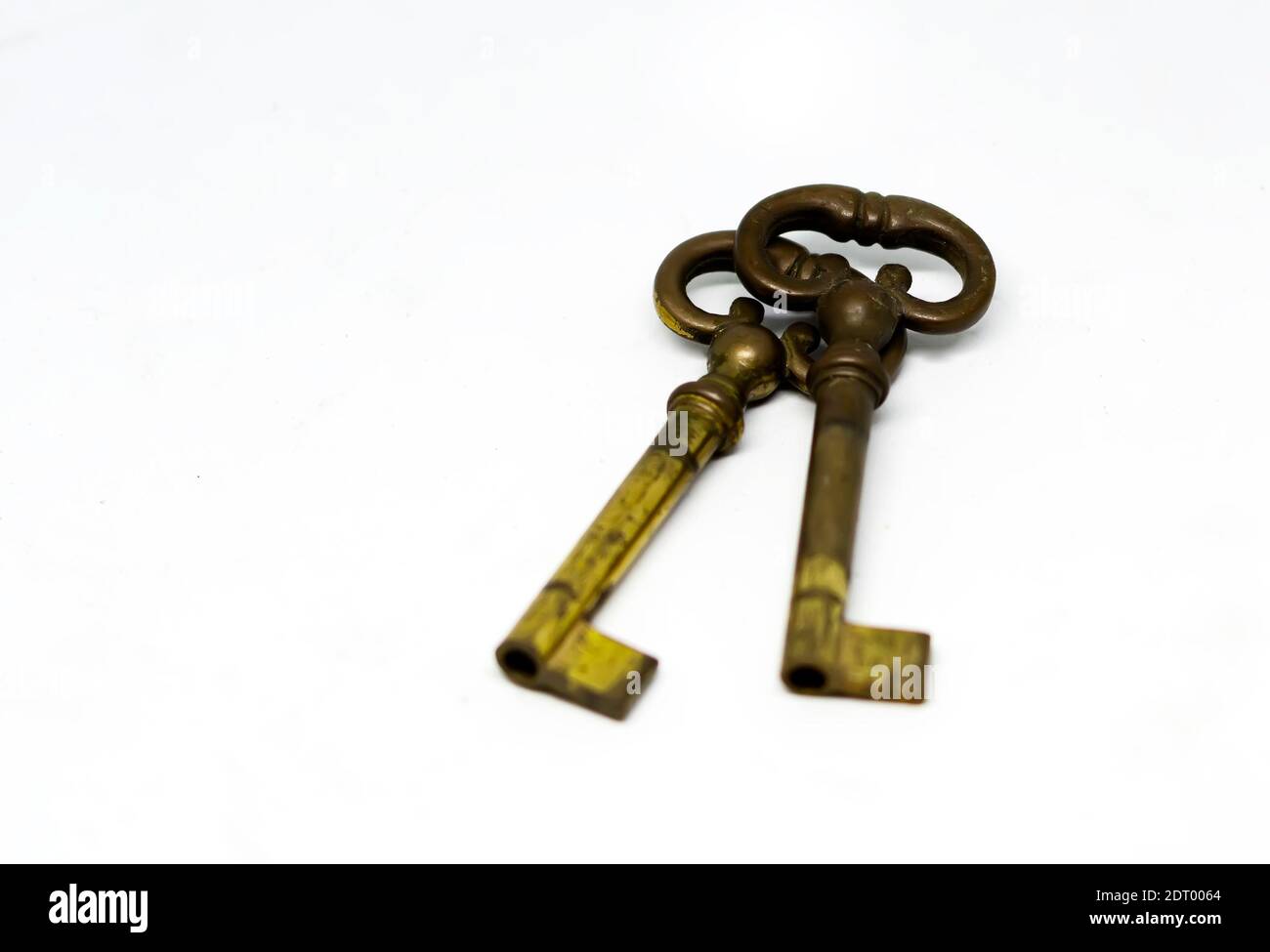 Una coppia di vecchie chiavi di ottone ossidate isolate su sfondo bianco. Concetto di sicurezza e protezione Foto Stock