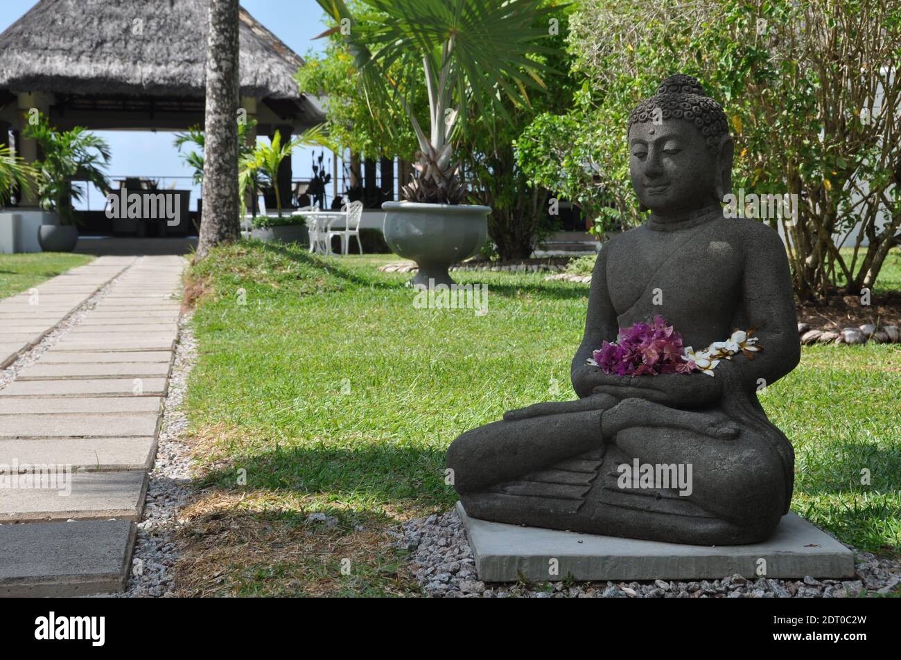 Statua di Buddha con fiori nell'isola di praslin, alle seychelles per un'esperienza mistica e spirituale Foto Stock