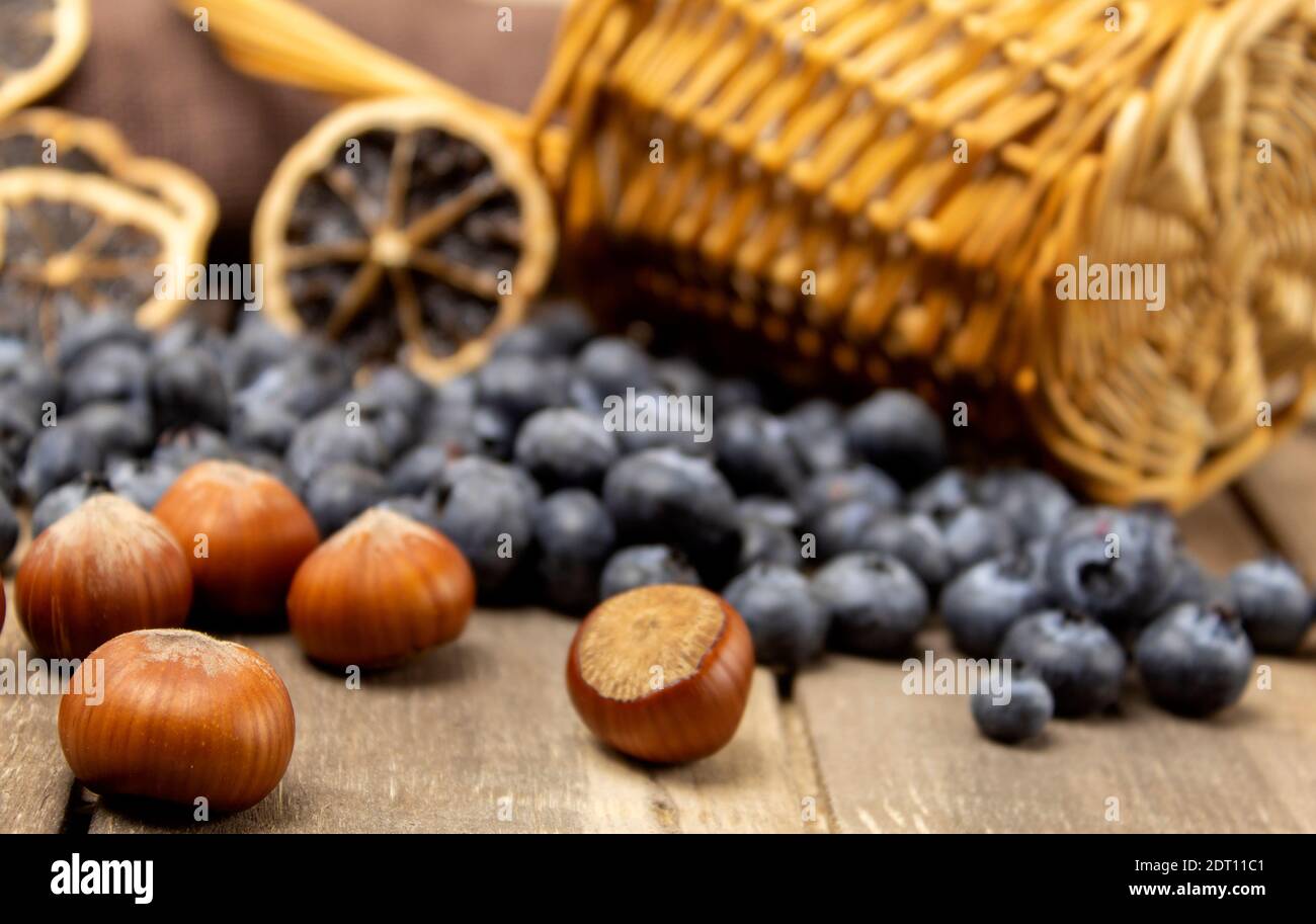 Mirtilli e nocciole su un tavolo di legno. Scorte alimentari per l'inverno, bacche e noci Foto Stock