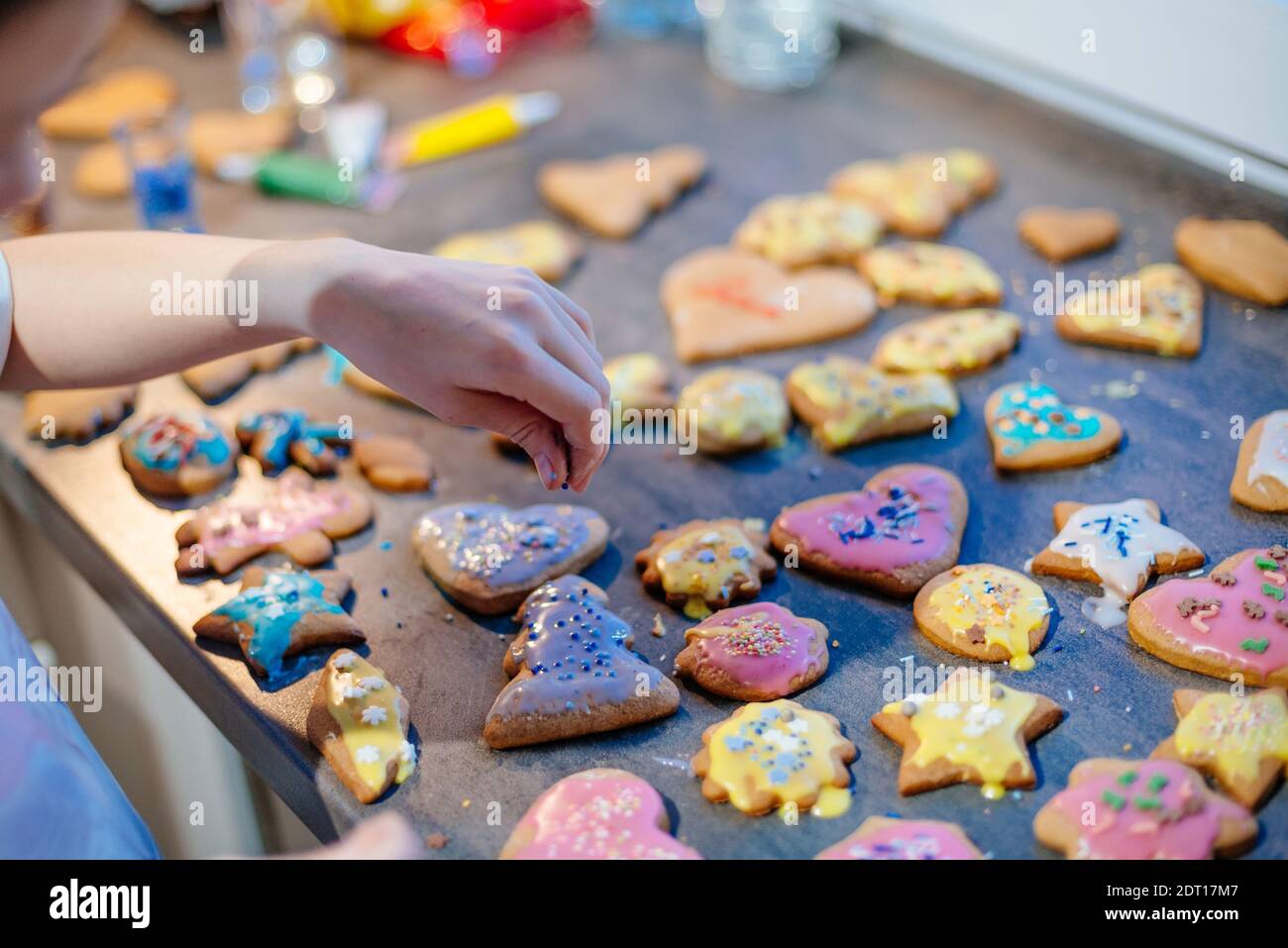 Ragazza che decora i biscotti di pan di zenzero a casa Foto Stock