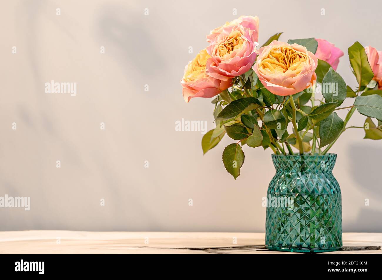 Bouquet rustico di rose in vaso sulla tavola alla luce del sole Foto Stock