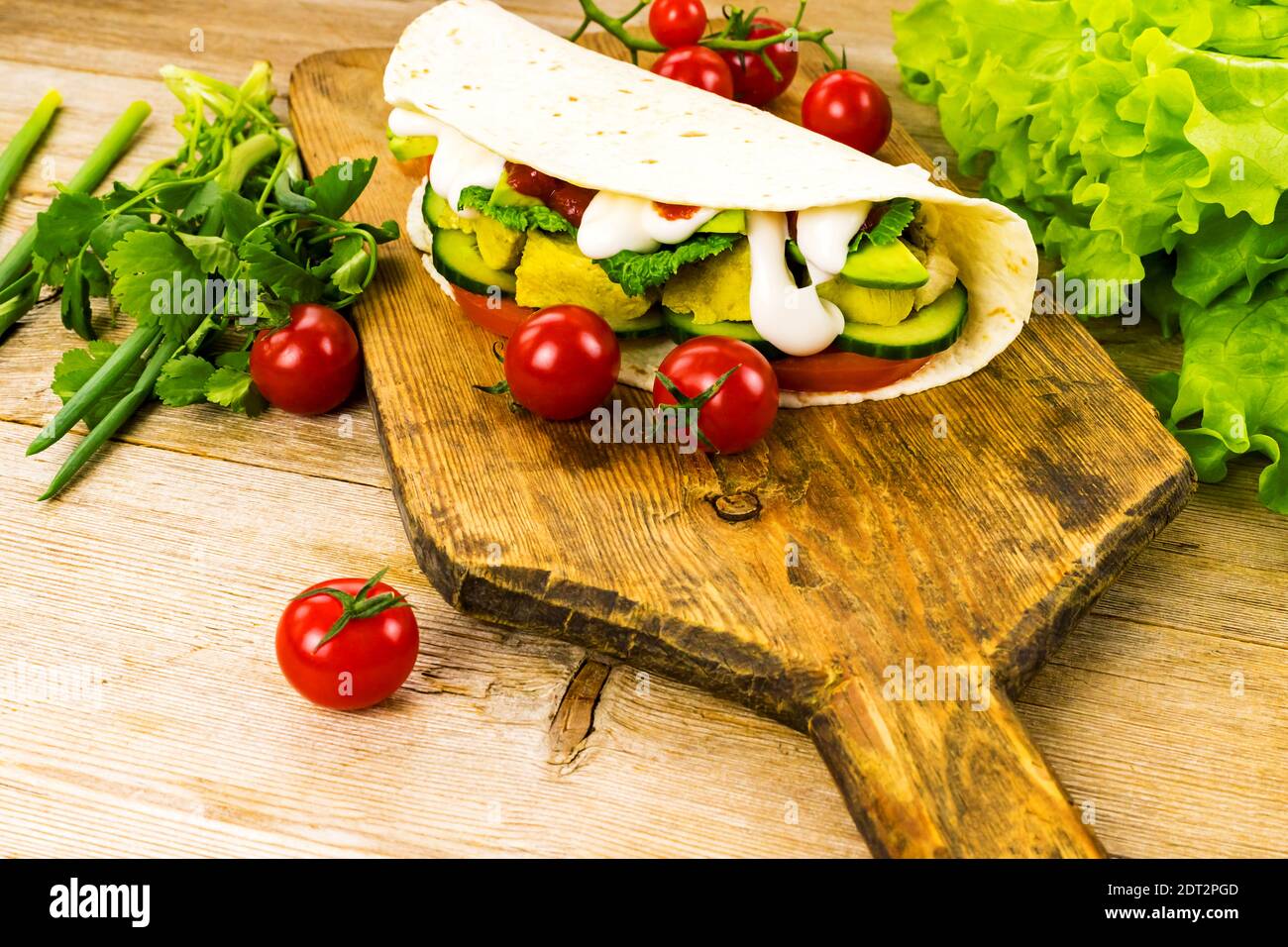 Pollo farcito shawarma tortilla tacos avvolge doner kebab sandwich gyros fast food con verdure su vecchio tagliere rustico. Messa a fuoco selettiva. Copia Foto Stock