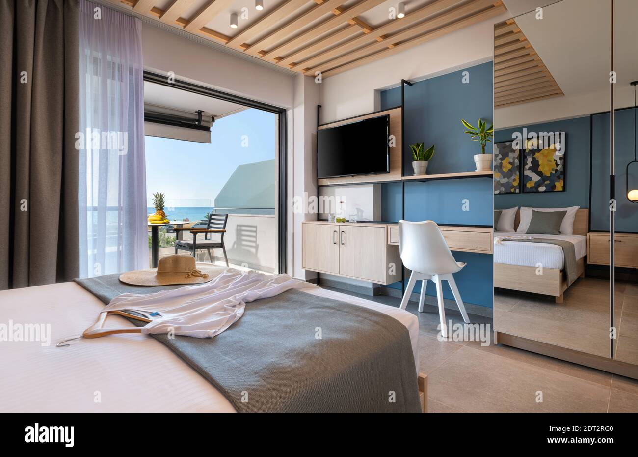 Camera da letto in stile loft moderno con dettagli in metallo, mobili in legno, armadio a specchio, decorazioni astratte. Appartamento con balcone vista mare, Frenc all'aperto Foto Stock
