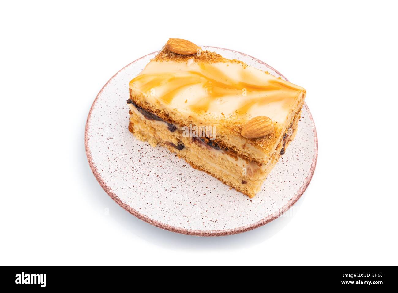 Torta al miele con crema di latte, caramello, mandorle isolate su fondo bianco. Vista laterale, primo piano. Foto Stock