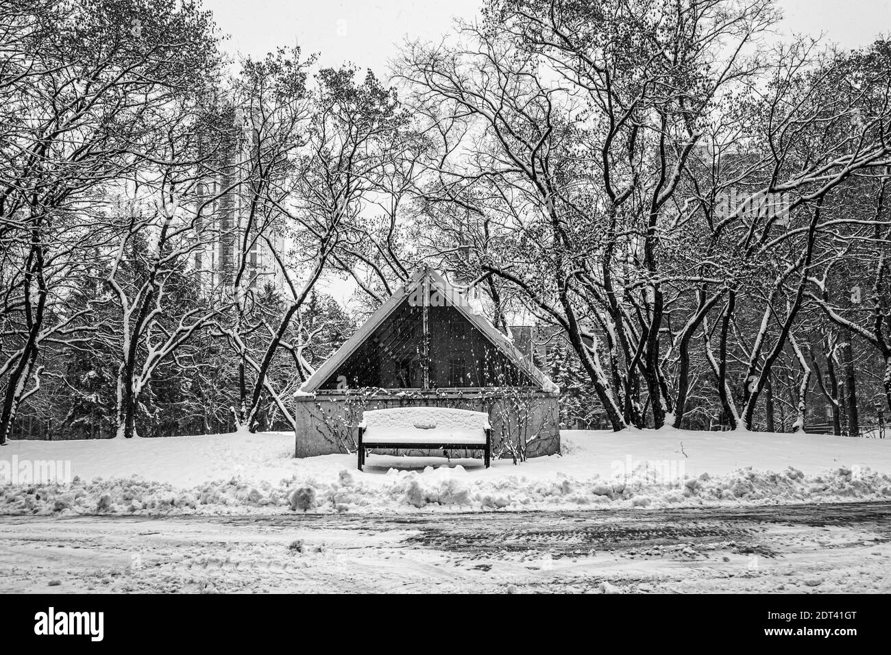 Vista di panca vuota e casa durante la stagione invernale Foto Stock