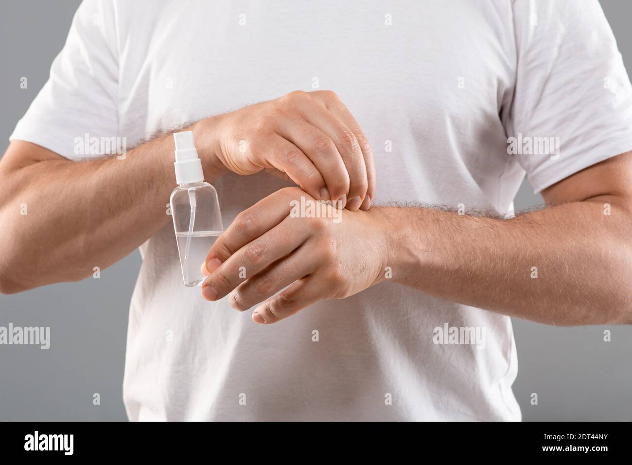 Uomo irriconoscibile che tiene lo spray, graffiando la mano Foto Stock