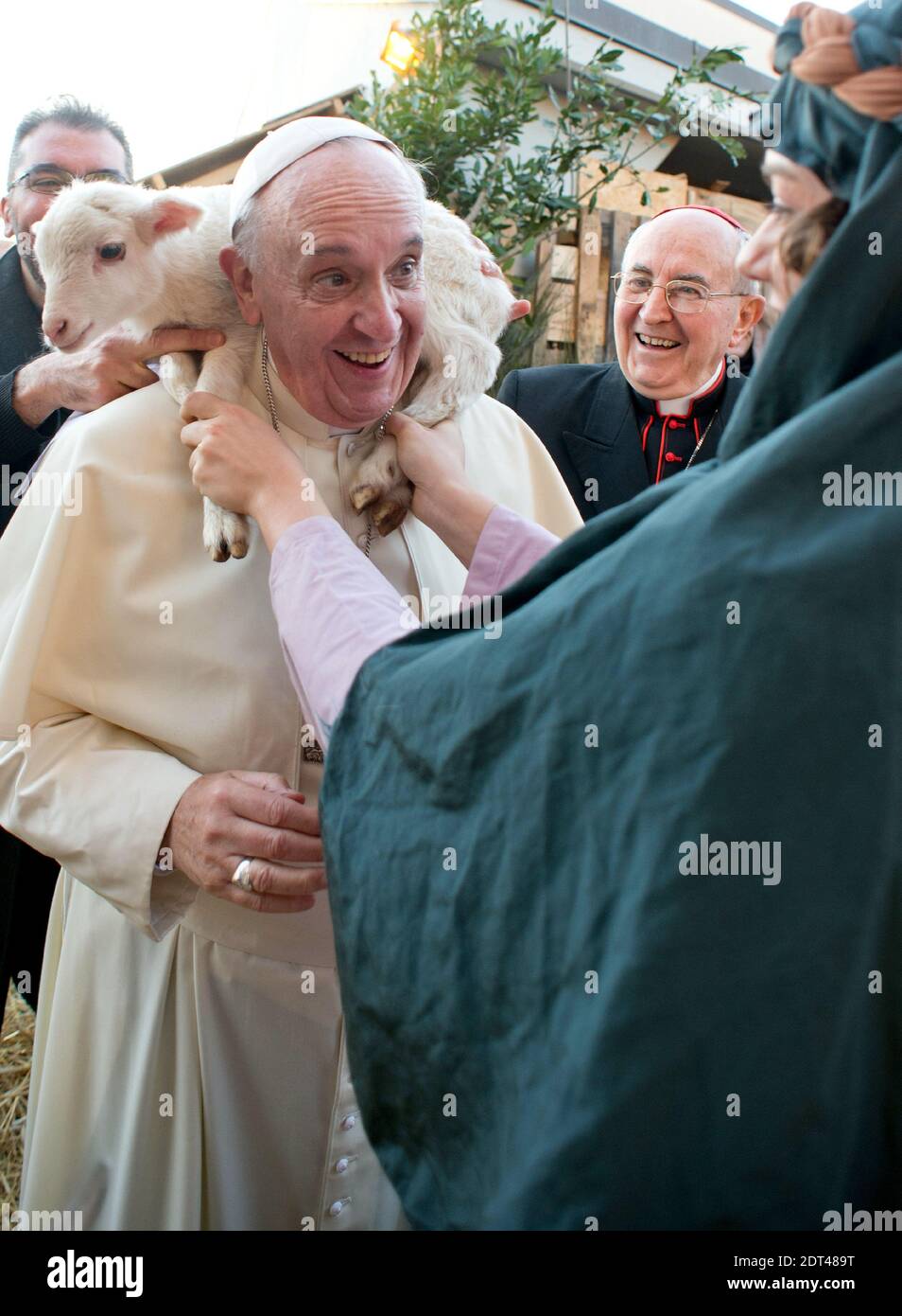 Una donna che partecipa a un presepe vivo pone un agnello sulle spalle di Papa Francesco nella Chiesa di Sant'Alfonso Maria dei Liguori, alla periferia di Roma, il 6 gennaio 2014. L'evento faceva parte della festa dell'Epifania, che commemora la visita di tre re al bambino Gesù dopo la sua nascita a Betlemme. Foto di ABACAPRESS.COM Foto Stock