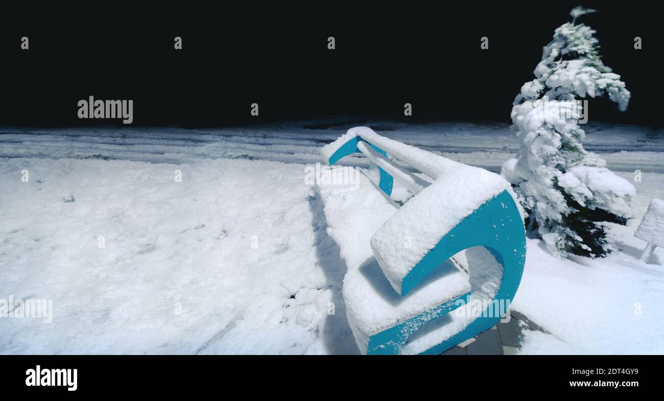 panca di pietra e abete durante la notte invernale Foto Stock