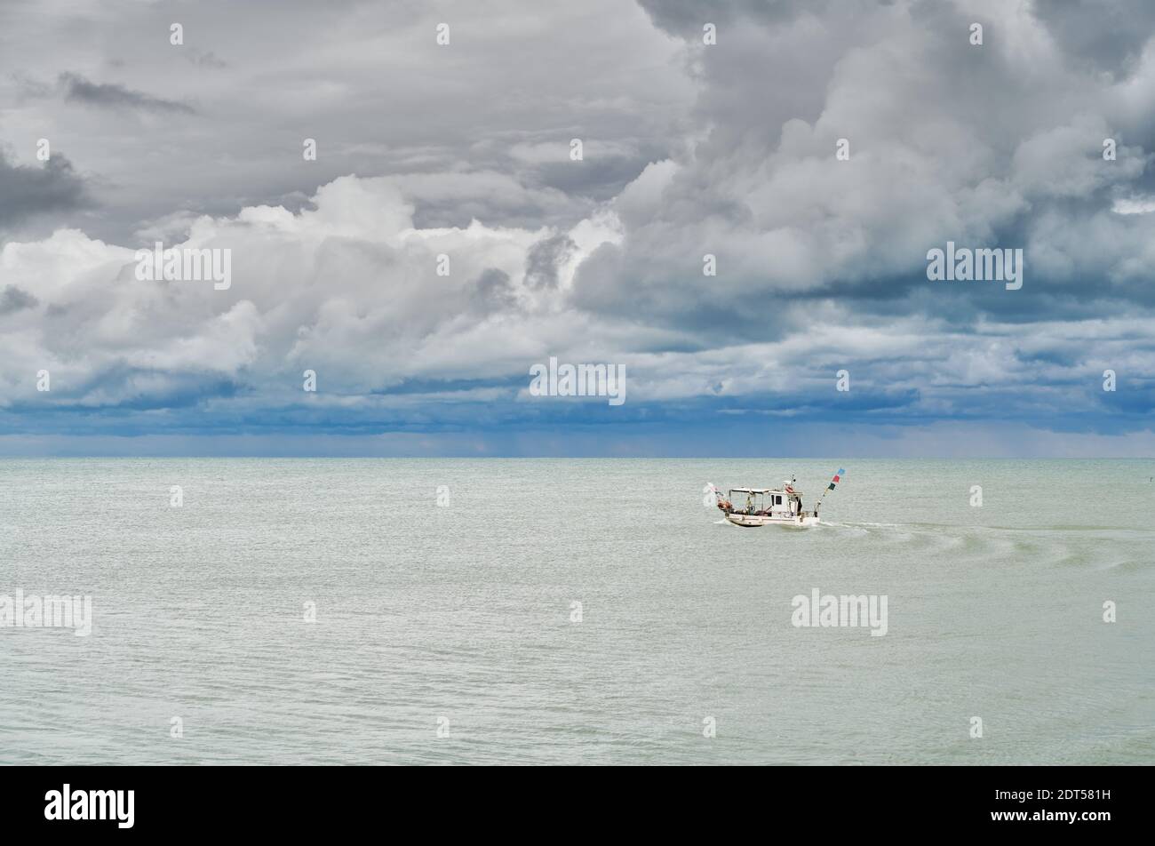 Piccola barca di pescatori in un giorno nuvoloso di settembre prima della tempesta, sulla costa veneziana vicino a Caorle Foto Stock