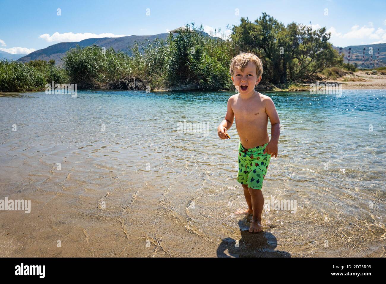 Ragazzino in piedi nudi in acqua Foto Stock
