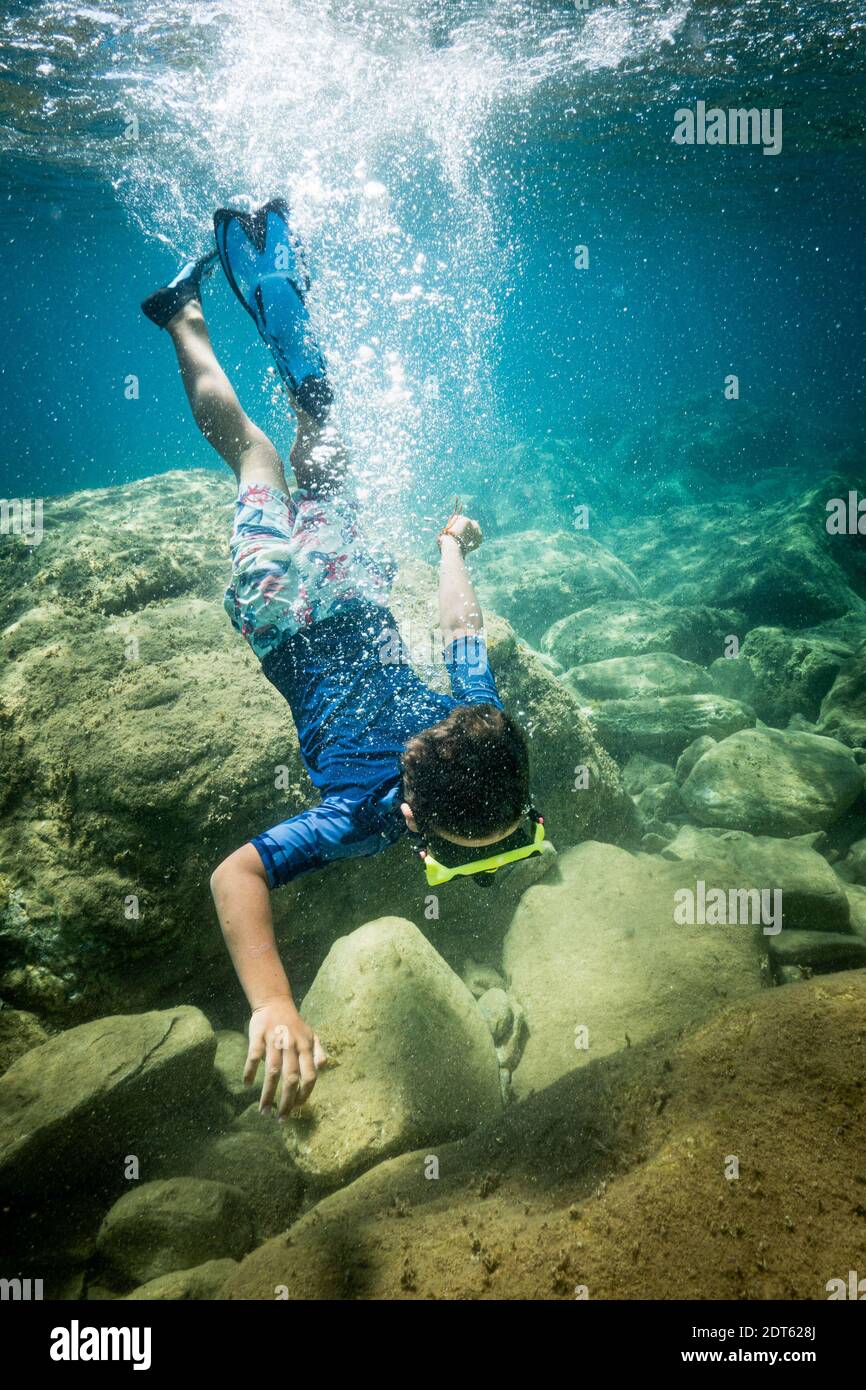 Ragazzo che indossa una maschera subacquea che nuota sott'acqua Foto Stock