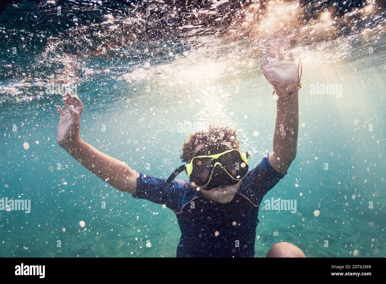 Ragazzo che indossa una maschera subacquea che nuota sott'acqua Foto Stock