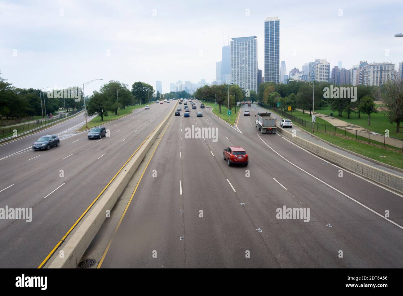 Autostrade che conducono a Chicago con edifici alti davanti e veicoli sfocati in movimento entrando e uscendo dalla città, Illinois, USA Foto Stock