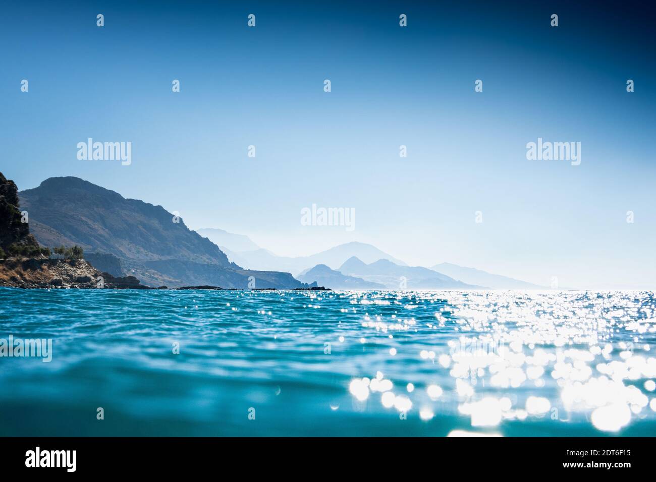 Vista sul mare blu con le montagne sullo sfondo Foto Stock