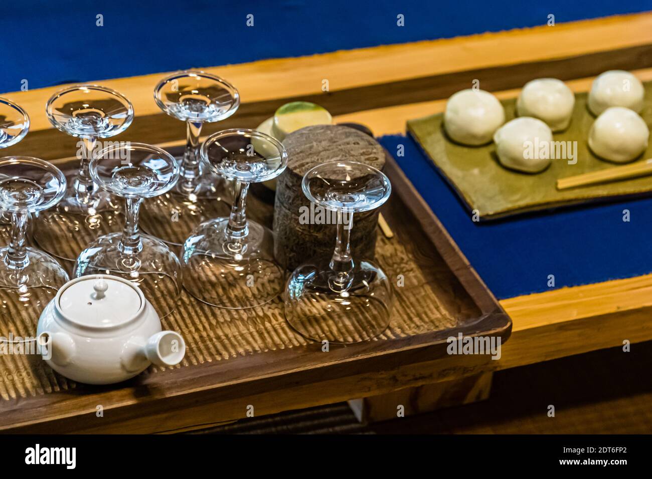 Vasi di vetro per la cerimonia del tè sono disposti accanto a una pentola di acqua calda e dolci wagashi su un vassoio alla fattoria del tè Sansuien vicino a Shizuoka, Giappone. Foto Stock