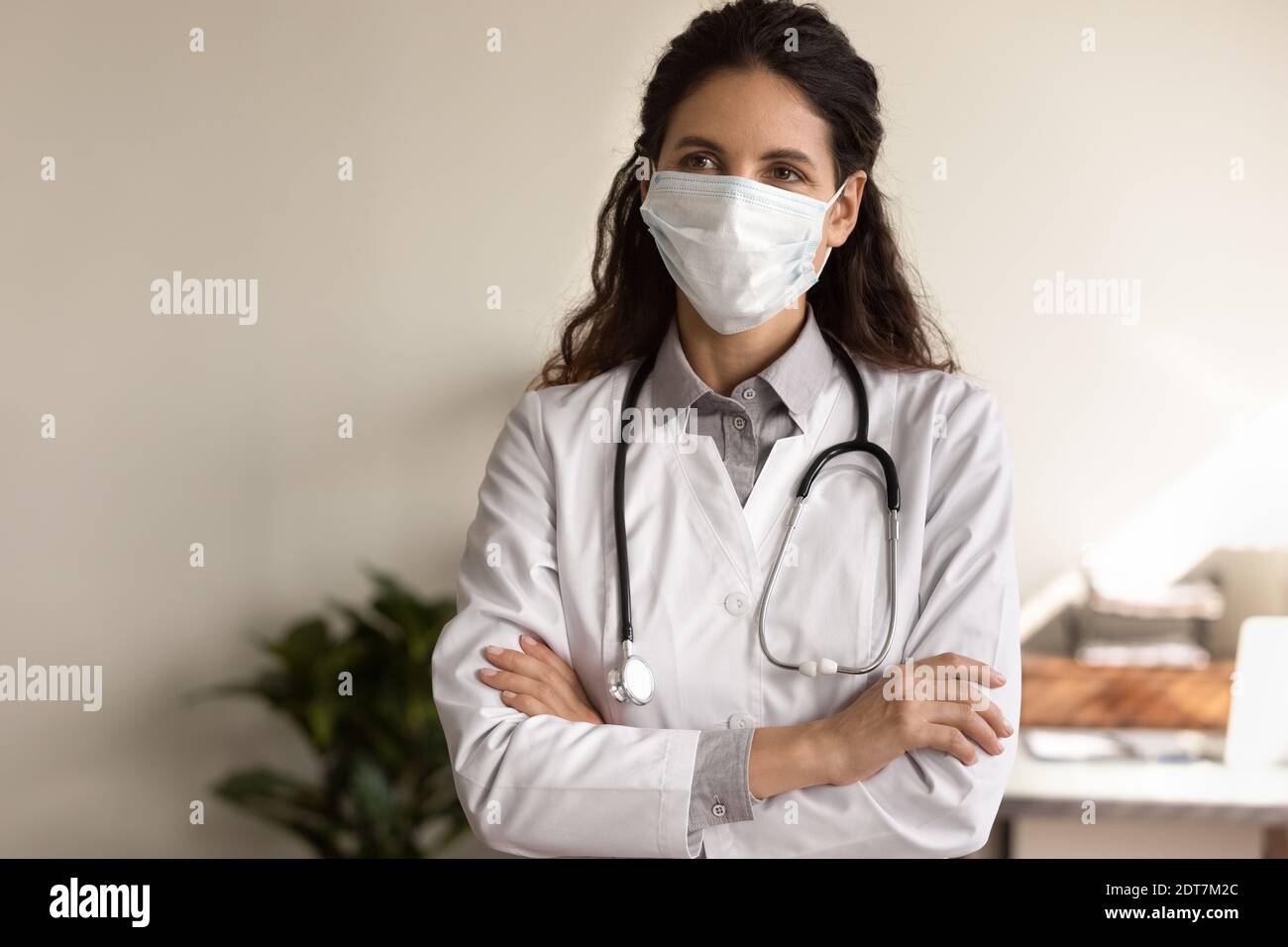 Medico femminile in maschera di viso lavoro in ospedale durante covid-19 Foto Stock