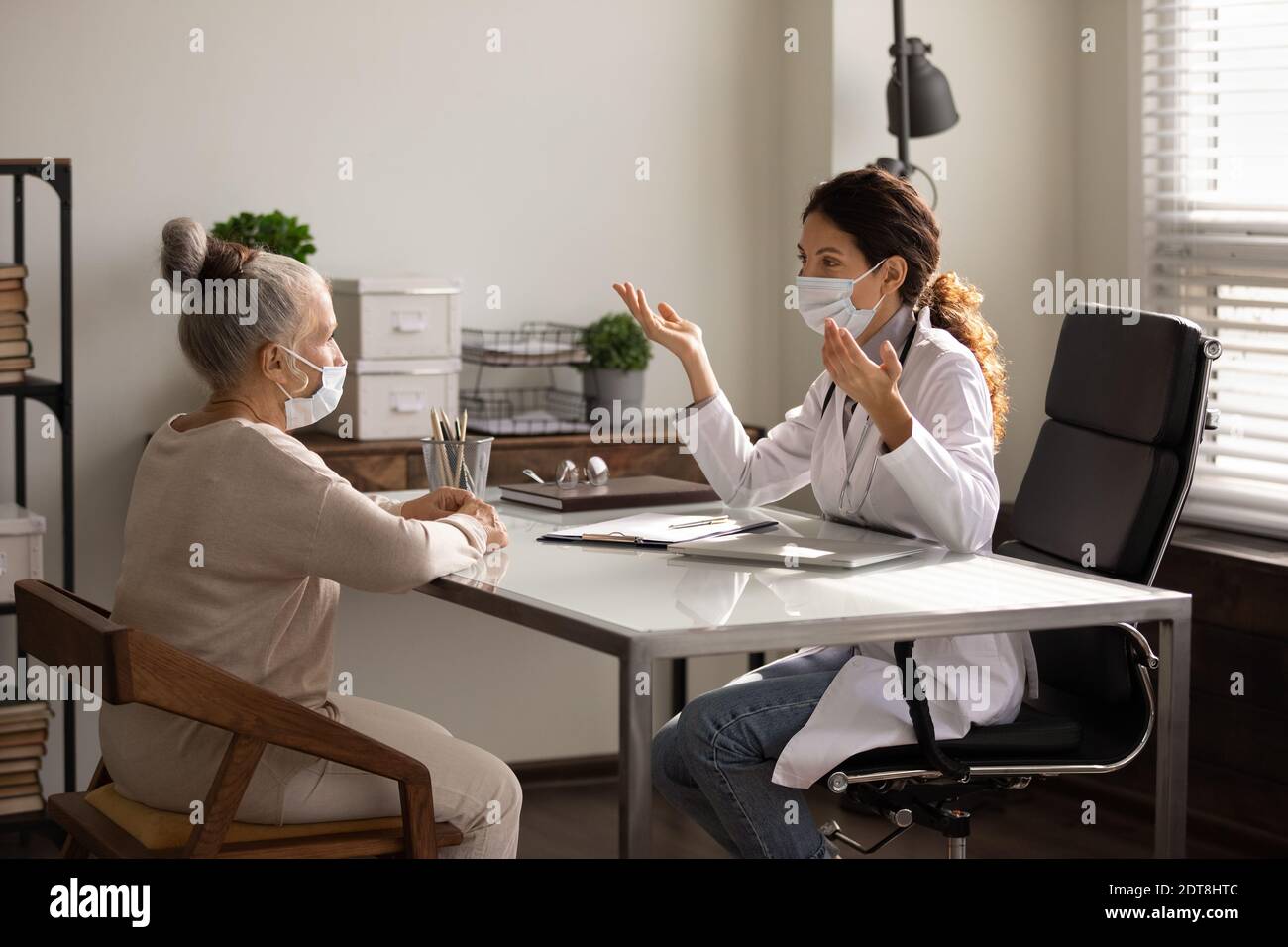 Medico femminile e paziente anziano in maschere facciali Foto Stock