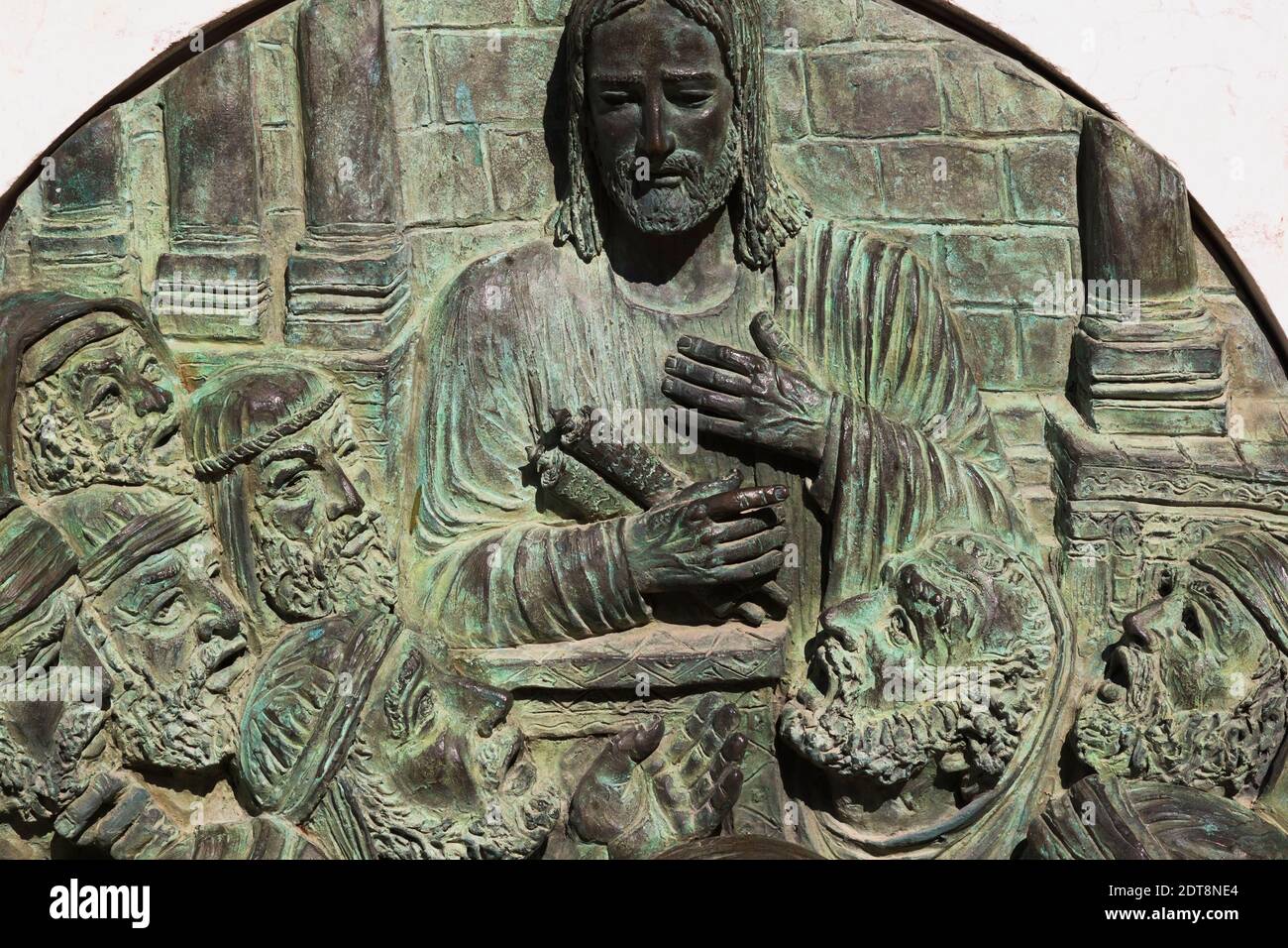 Targa di bronzo con scena religiosa scolpita inserita nella base del monumento in marmo nel cortile interno della Chiesa dell'Annunciazione, Nazareth, Israele. Foto Stock