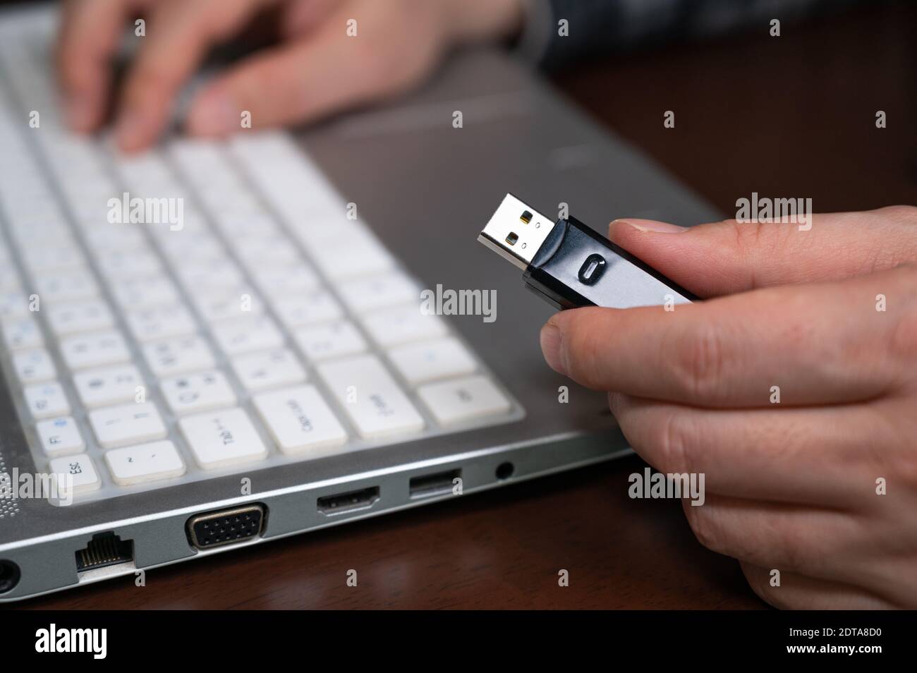 La mano di una persona che utilizza una memoria USB. Concetto di protezione delle informazioni informatiche. Messa a fuoco selezione USB. Foto Stock