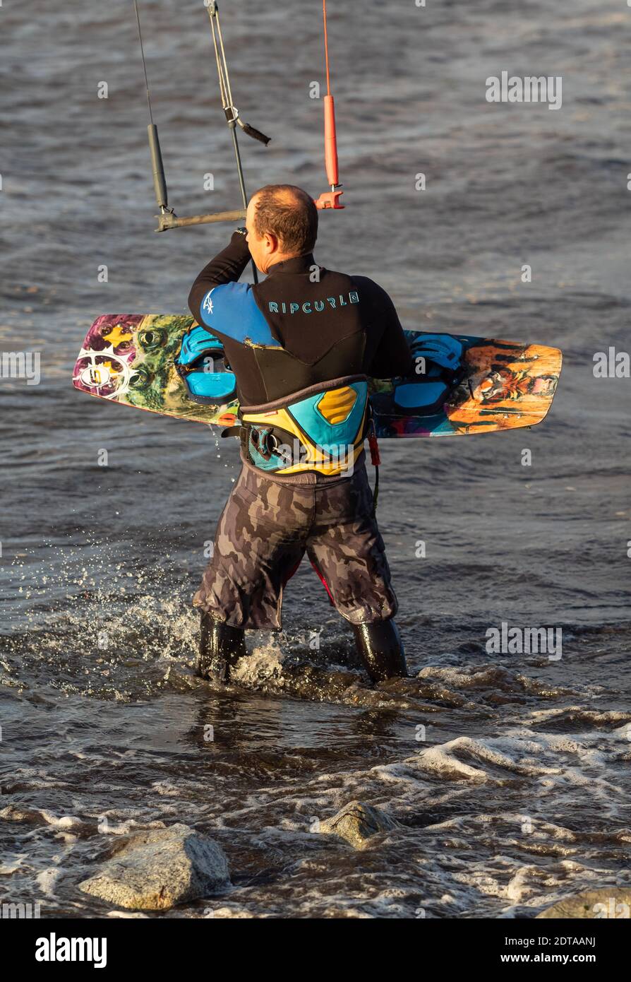 Kite surfer che entra in acqua sulla spiaggia. White Rock, British Columbia, Canada. Ottobre 13,2020. Messa a fuoco selettiva, foto sportiva, verticale. Foto Stock