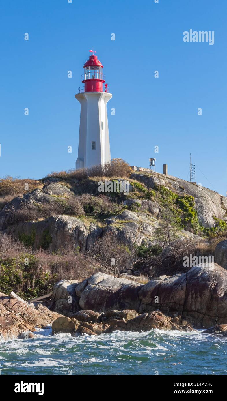 Splendido faro sulla riva rocciosa e le onde dall'oceano. Vancouver Ovest, British Columbia, Canada-Novembre 7,2020. Messa a fuoco selettiva, viaggio Foto Stock