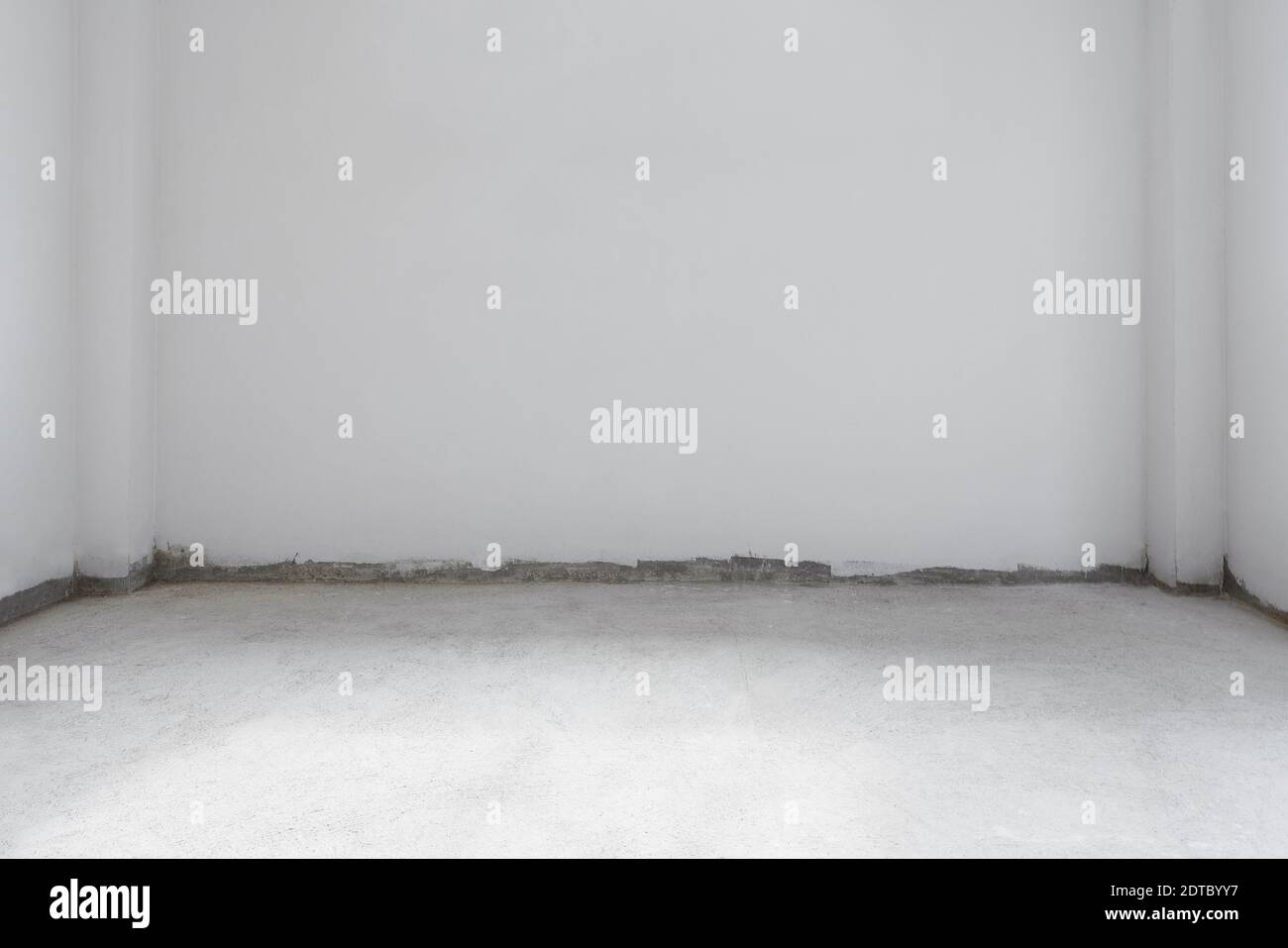 Sala in fase di ristrutturazione, pavimento in cemento con pareti bianche Foto Stock