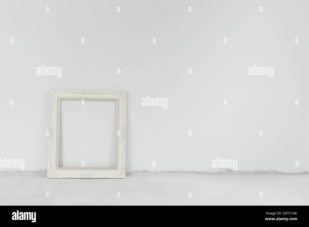 Parete bianca e pavimento in cemento, con cornice d'epoca. Sfondo della stanza Foto Stock