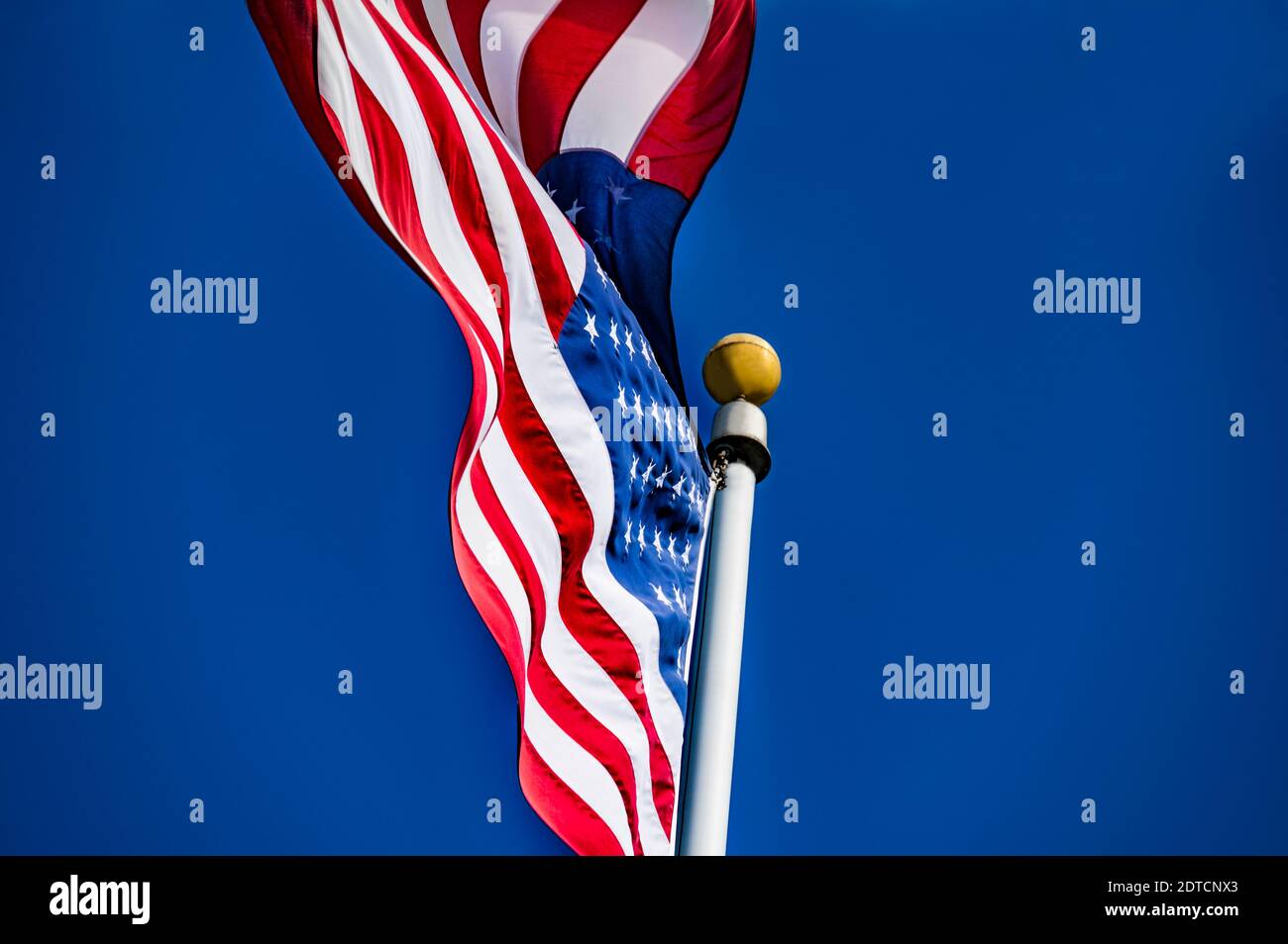 Bandiera americana che soffia nel vento contro il cielo blu Foto Stock