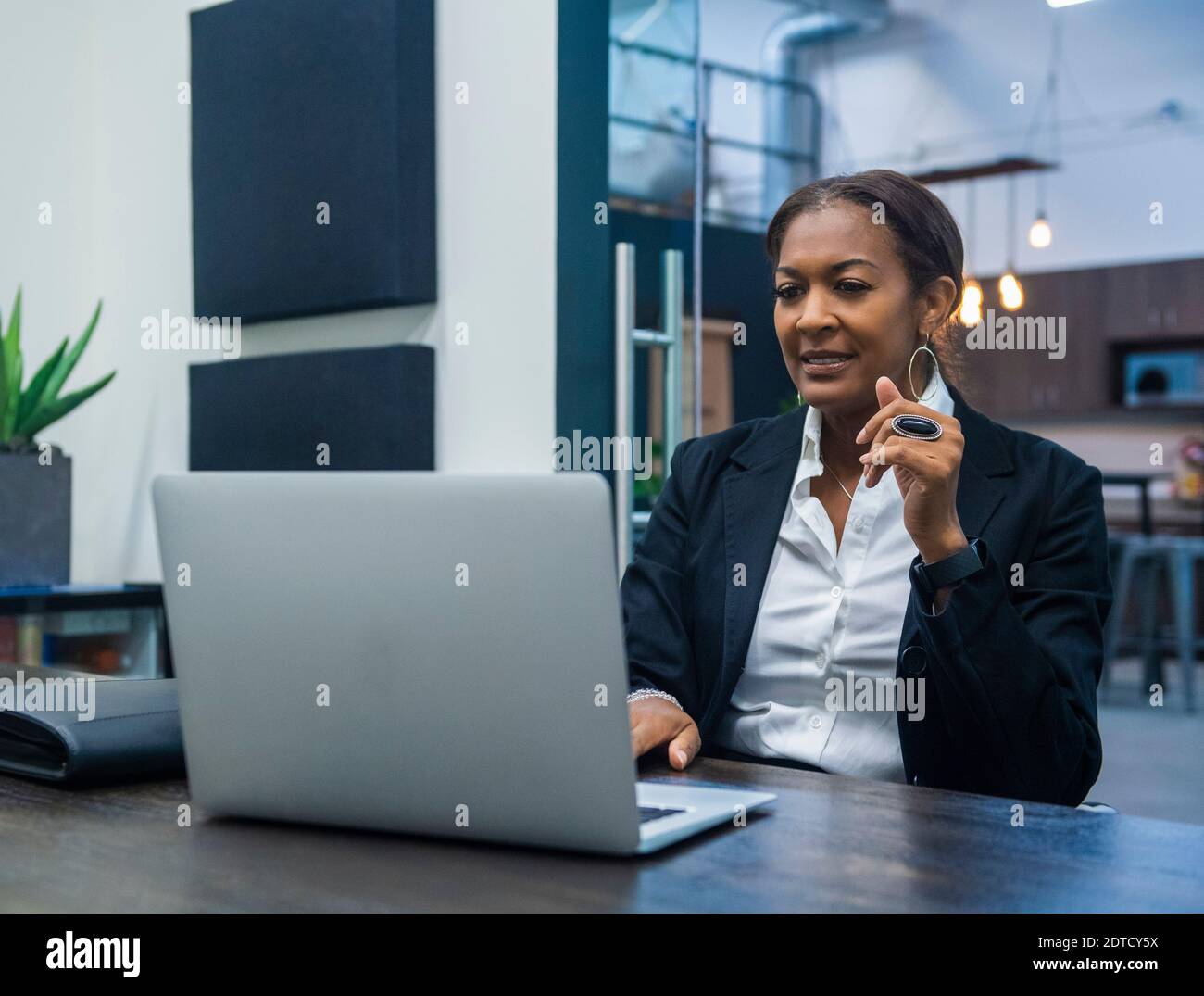 Imprenditrice lavorando sul computer portatile alla scrivania in ufficio Foto Stock