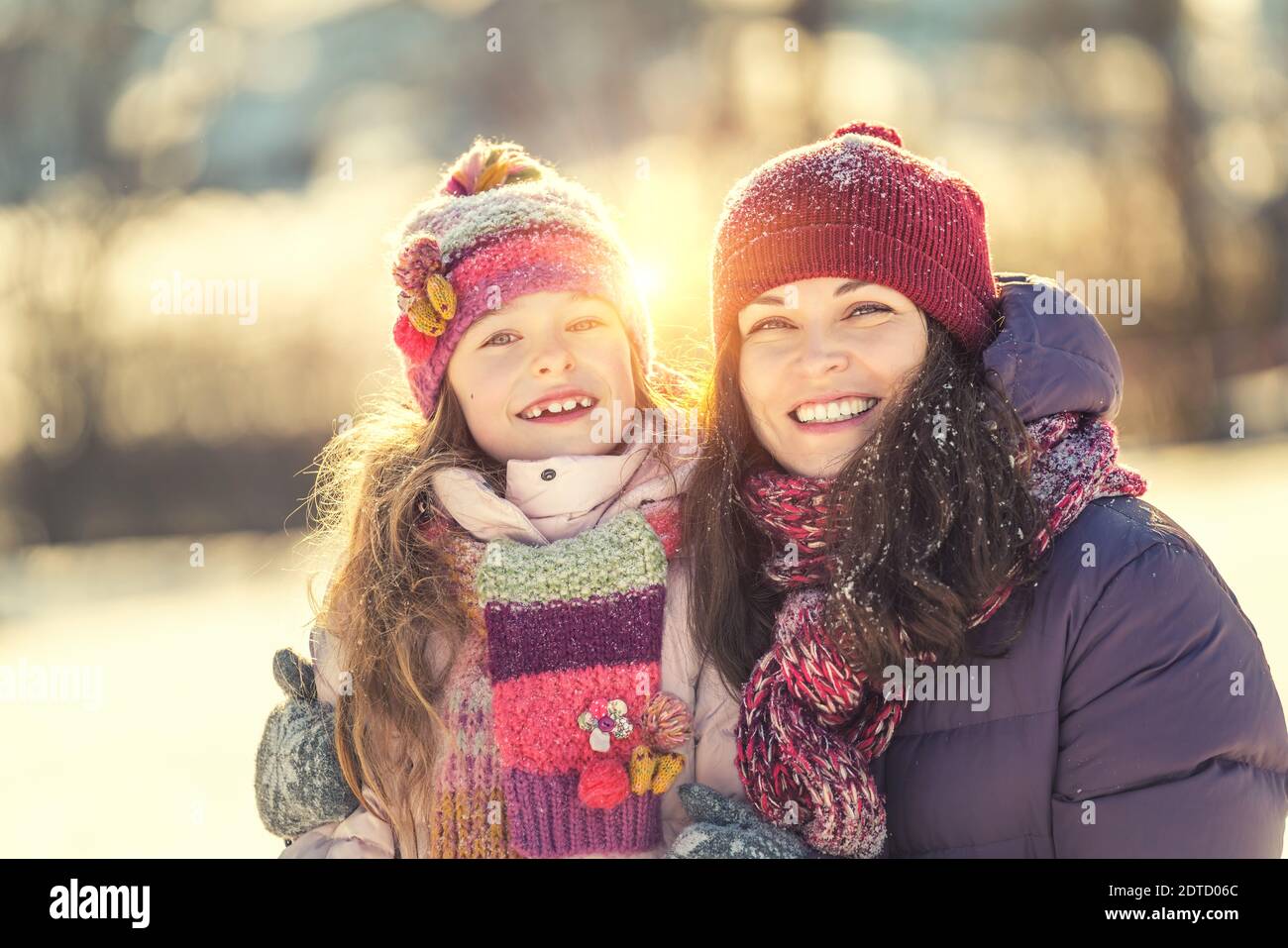 Bambina e sua madre giocano all'aperto durante il giorno di sole invernale. Concetto attivo di vacanze invernali. Foto Stock