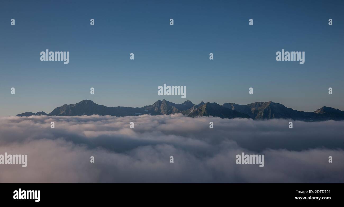 Svizzera, Monte Rosa, catena montuosa e nuvole sotto il cielo limpido Foto Stock