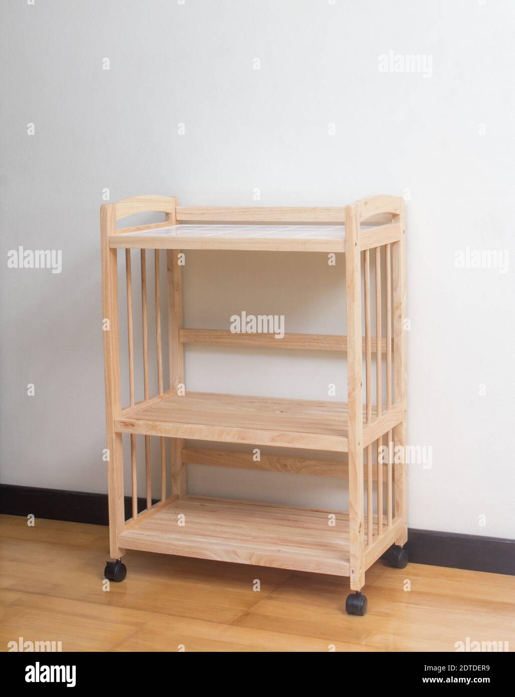 Scaffali in legno con ruote su pavimento in legno e sfondo bianco Foto Stock