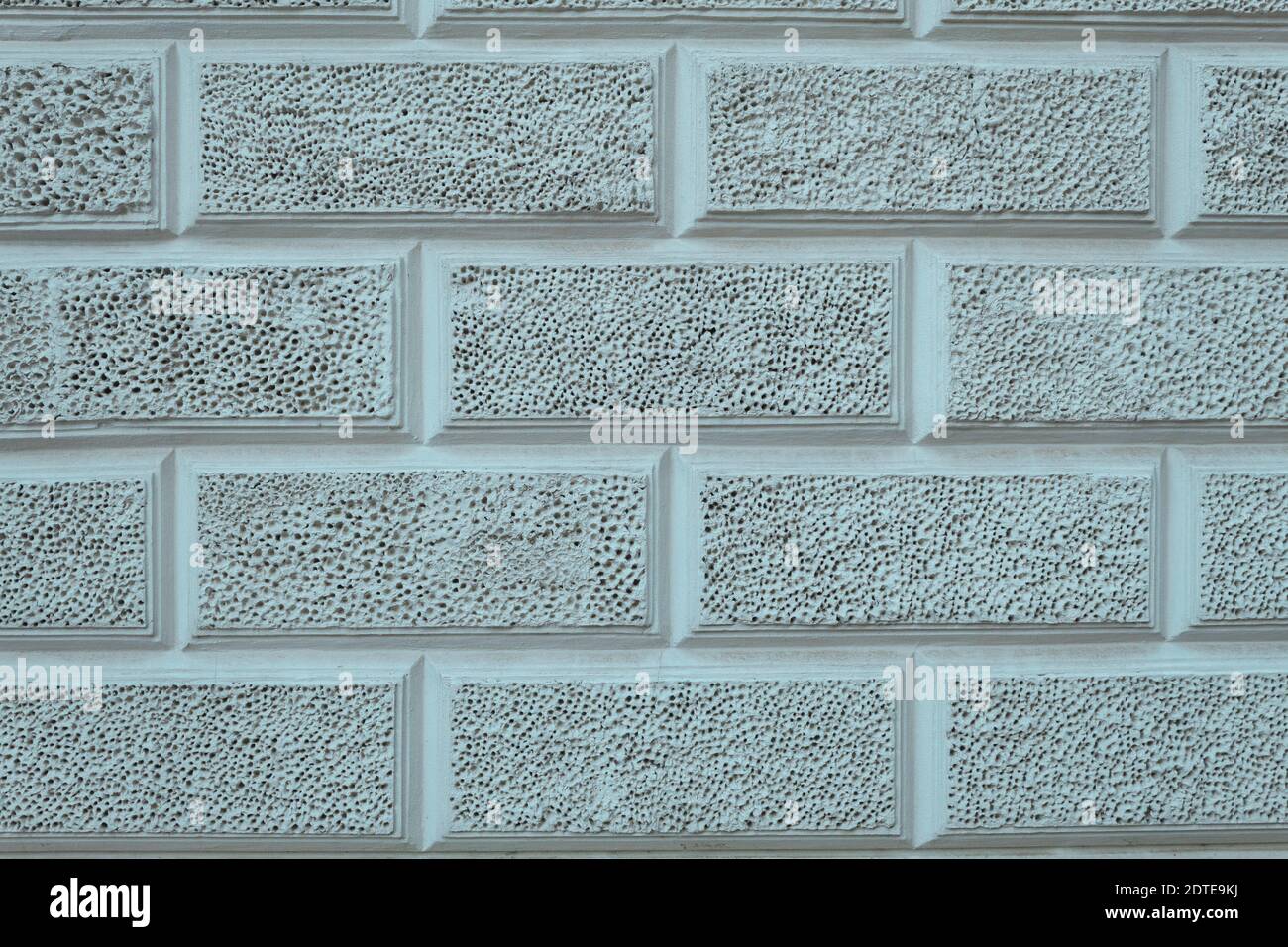 Texture parete di calcestruzzo con piccoli fori. Sfondo carta da parati una parete di cemento in forma di pietre con micro fori. Muro di pietra con fori Foto Stock