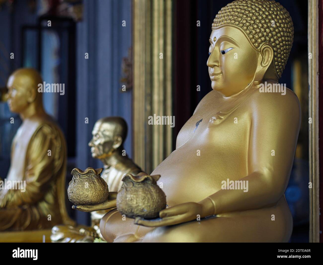 Un Buddha con la sua decorazione a pentola che tiene pouches che simboleggiano la ricchezza e la prosperità a Wat mai Amarot, Banglamphoo, Bangkok, Thailandia Foto Stock