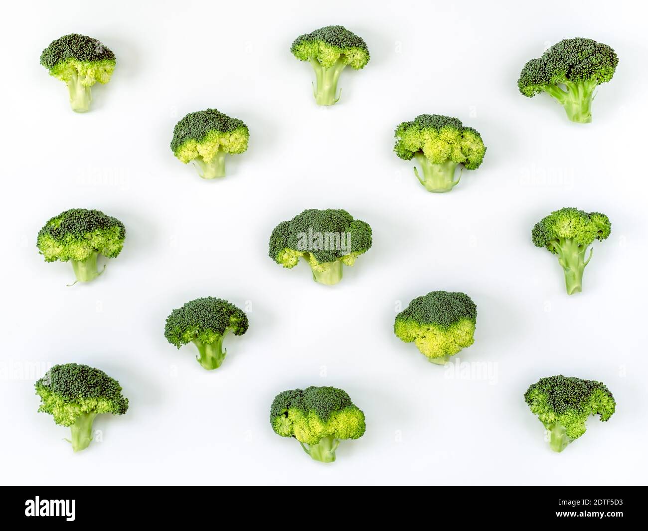 Immagine di un gruppo di broccoli grezzi posto su a. sfondo di cartone bianco e catturato dall'alto Foto Stock